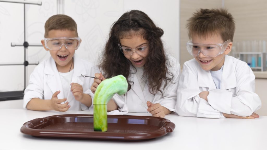 Three children watching a science experiment. 