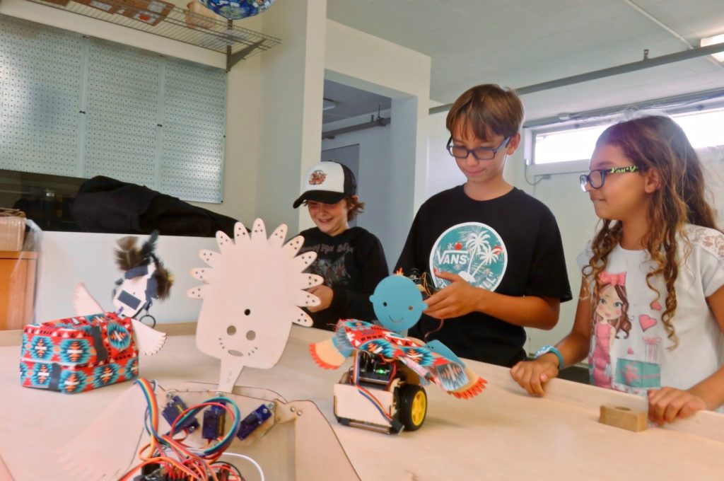 Image of kids with completed robot kit projects. 