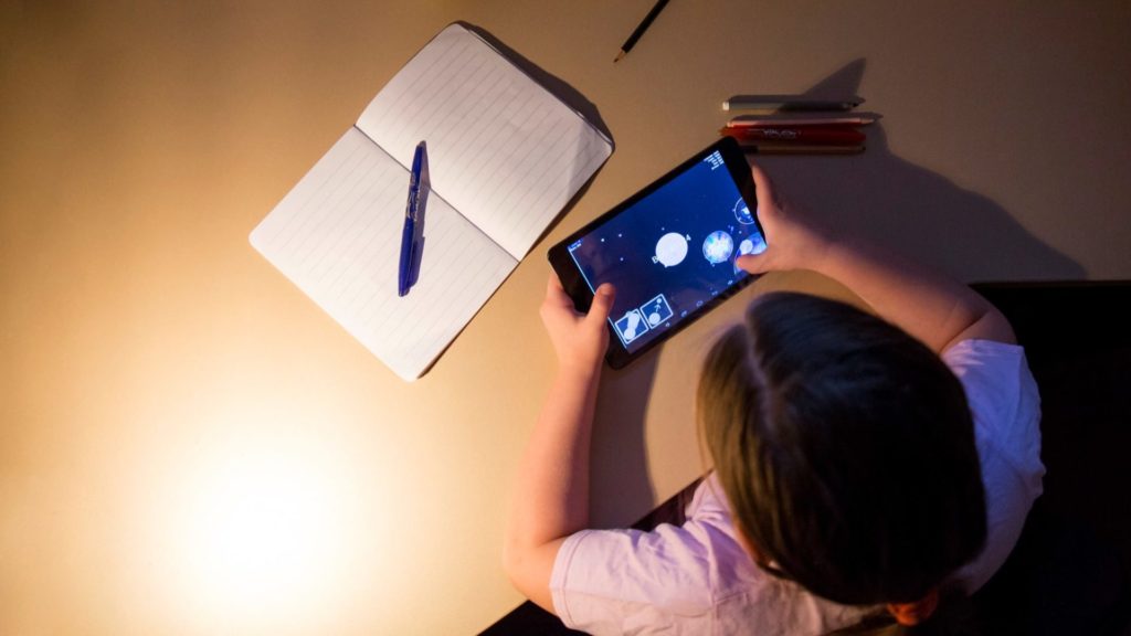 Girl using astronomy app on a tablet. 