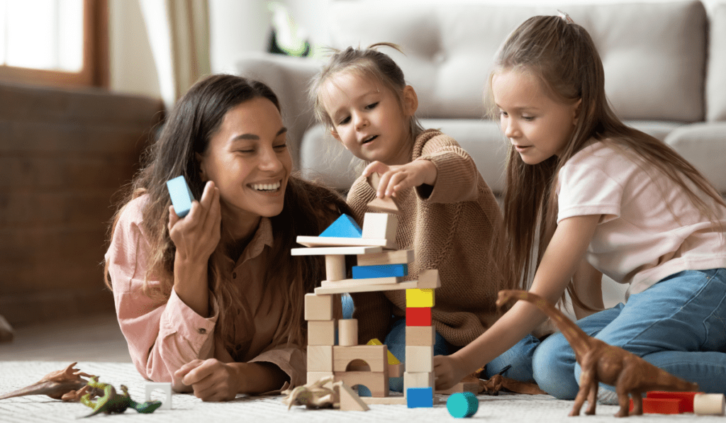 Mom playing blocks with her daughters. 