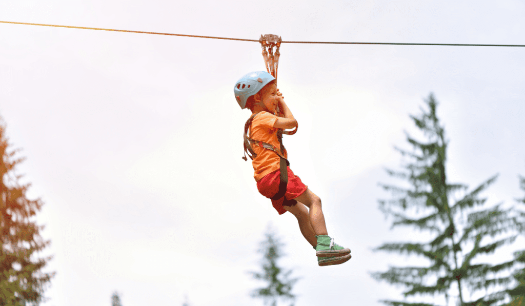 Child on a zipline that uses a pulley. 