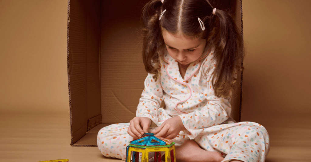 Girl playing with magnetic blocks. 