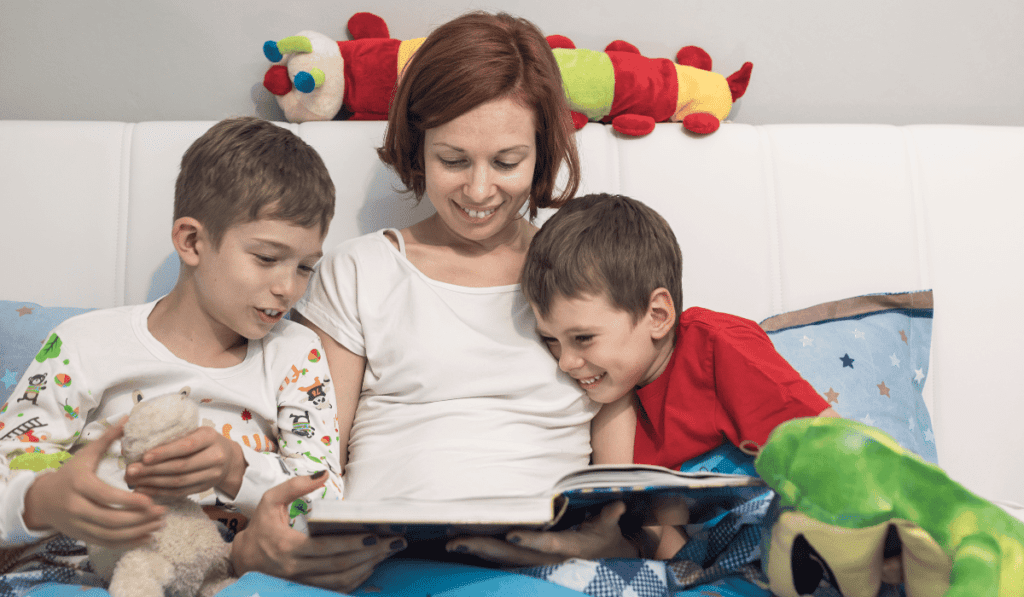 Mom reading to sons at bedtime. 