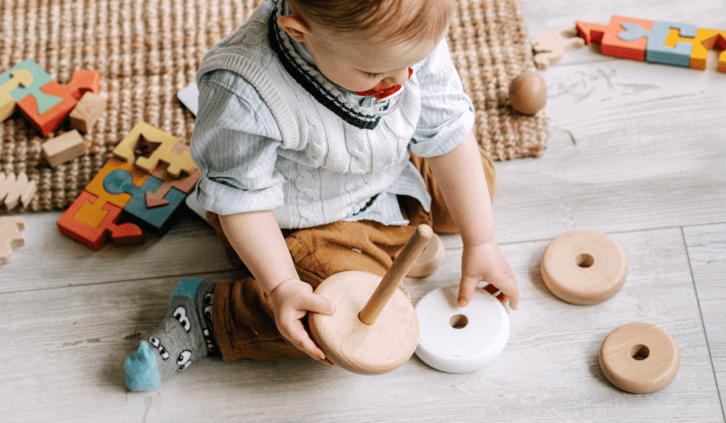 Infant playing with stackable blocks.