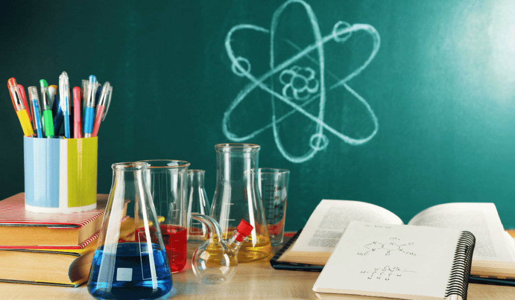 Image of chemistry set beakers and notebooks. 