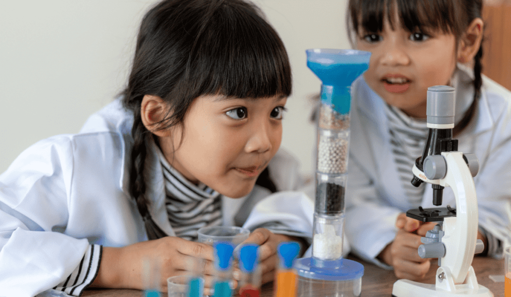 Image of two girls performing a chemistry experiment. 