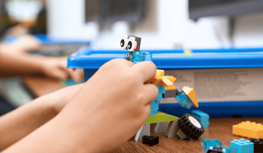 Close-up of a child building a robot.