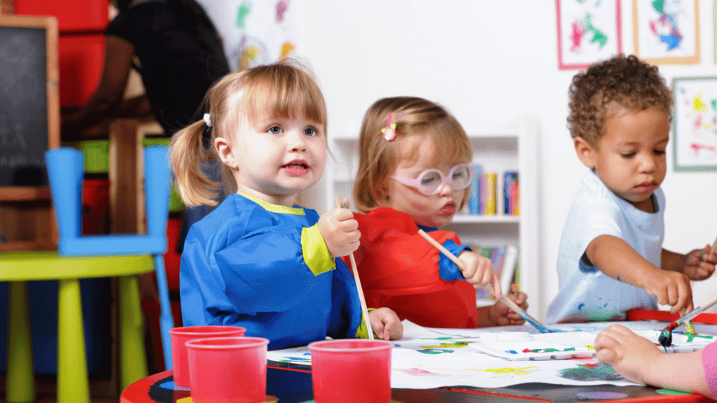 A group of toddlers engaging in different art activities.