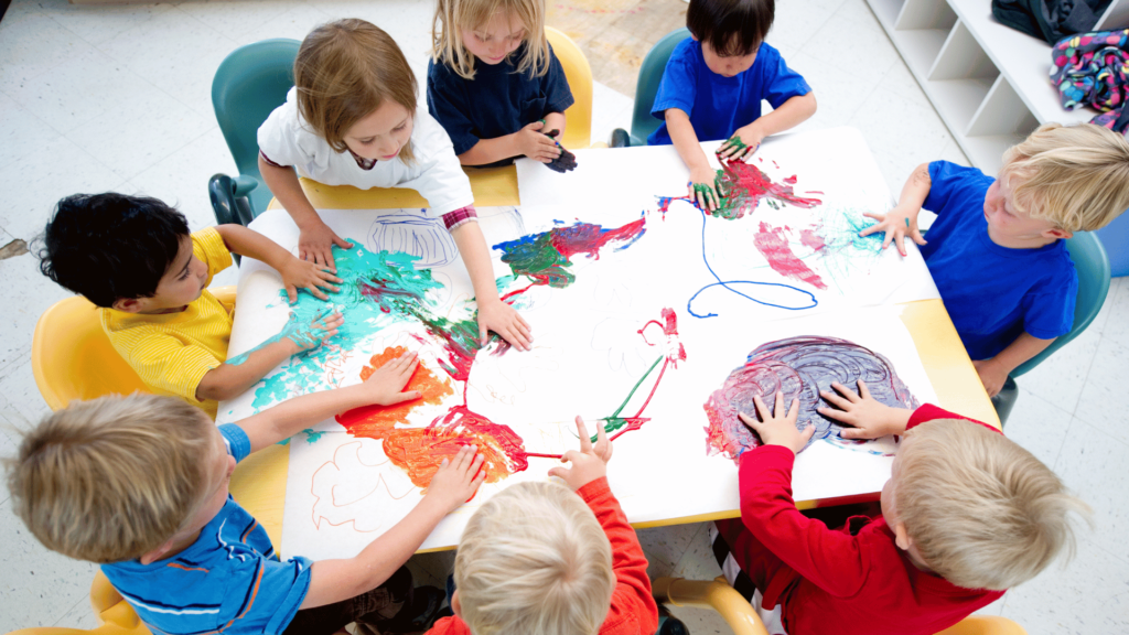 Group of toddlers finger painting.